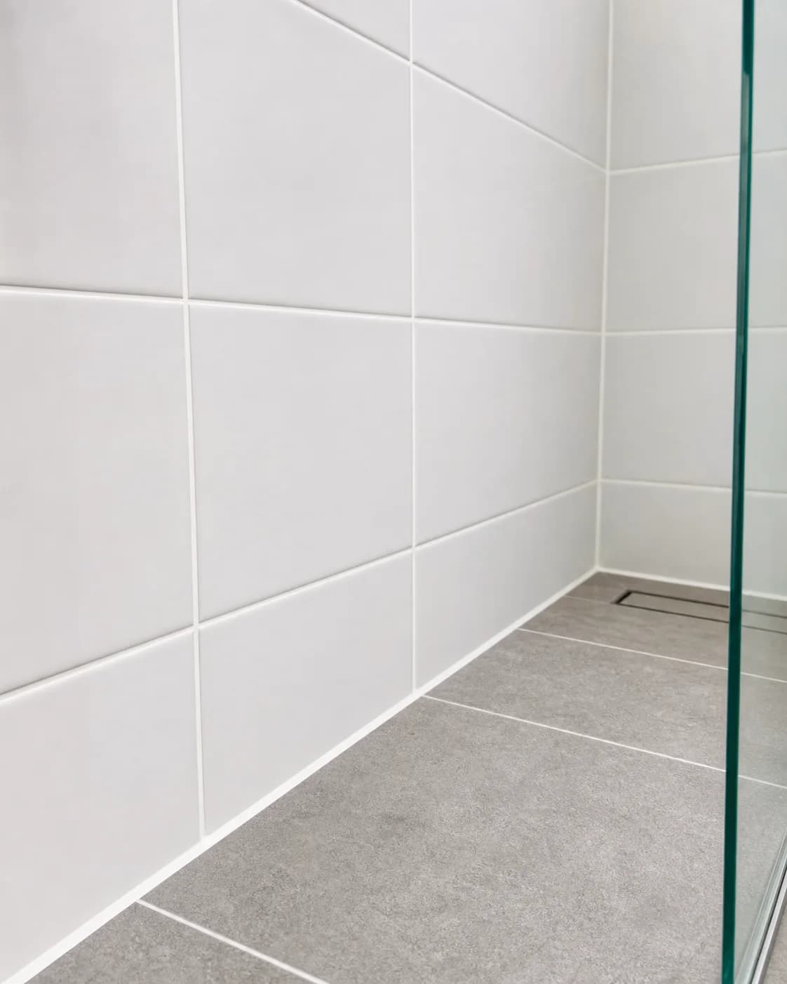 Fresh shower grout and silicone lines in a clean tiled wet area